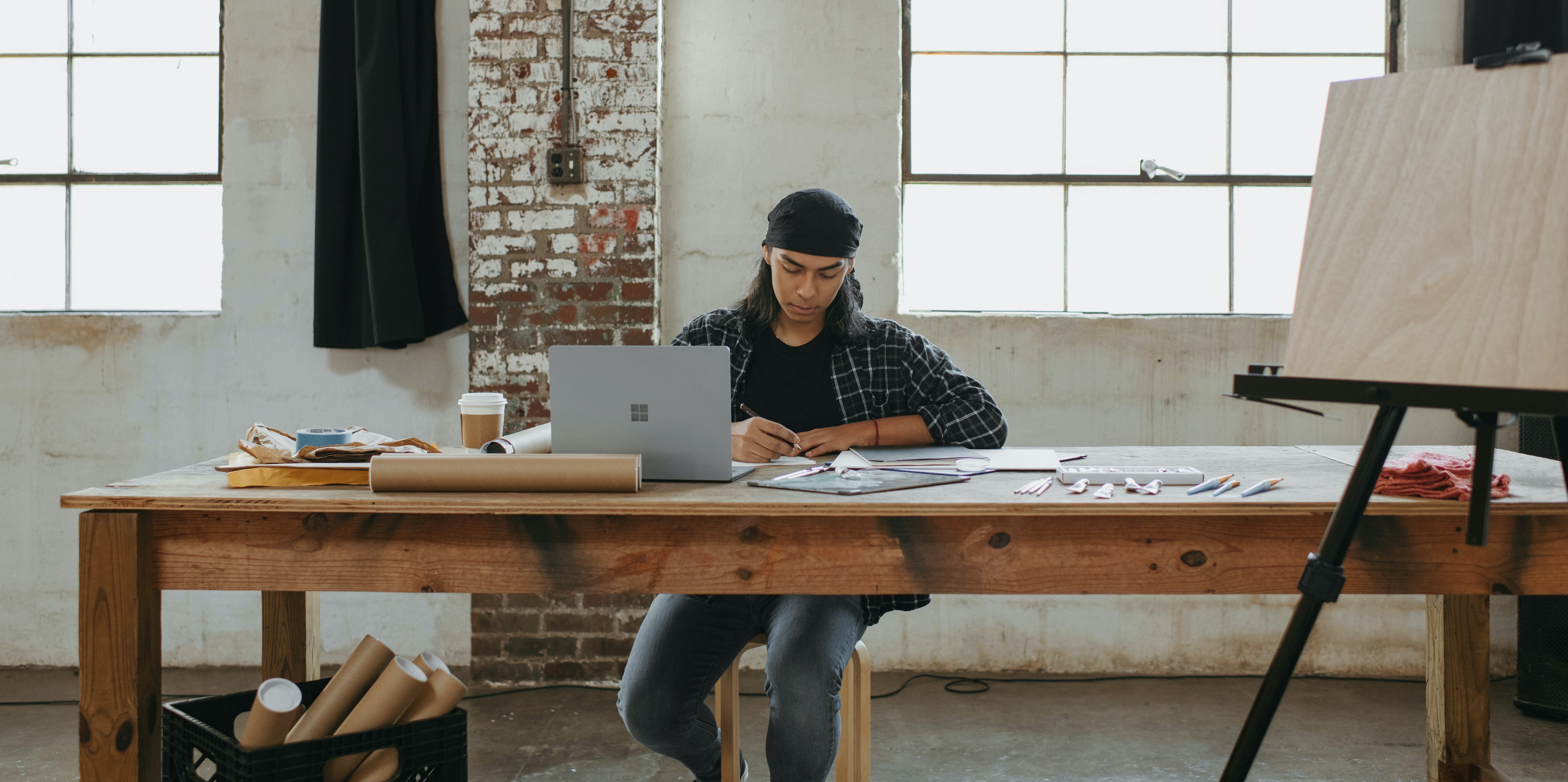 An artist works at their desk. 