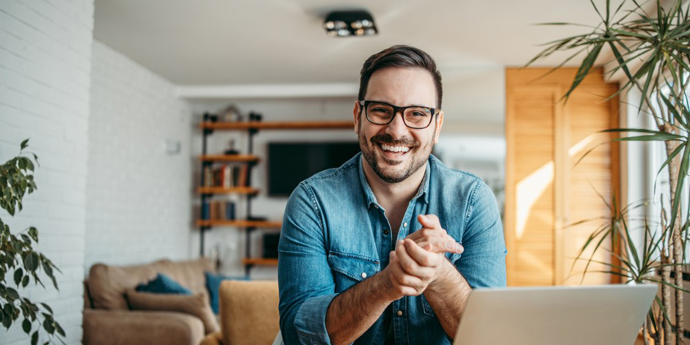 Man with laptop smiling 