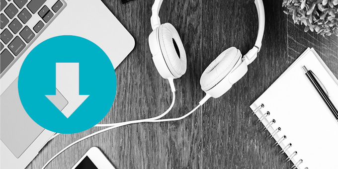 Black and white bird's eye view photo of a table top with a laptop, headphones, and notebook