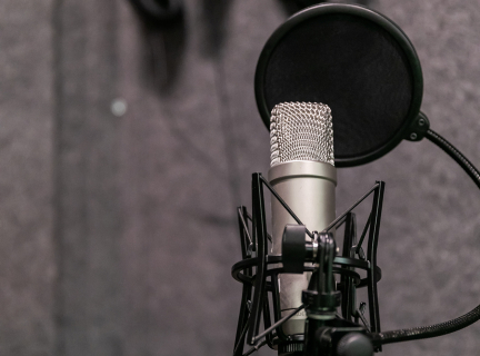 Microphone infront of a gray recording studio wall