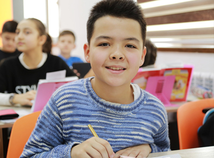 A smiling boy in a blue and white striped sweater