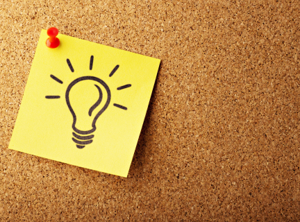 Photo of a bulletin board with a post-it-note depicting a lightbulb