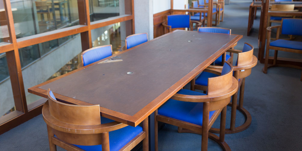 The Central Library L6 North meeting room The Central Library L6 North meeting room towards the door. There is one rectangular table surrounded by six chairs and two additional chairs facing towards the camera on either side of the door.